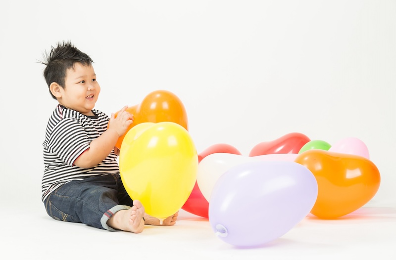 Obese boy on white background,Playing with balloon happily