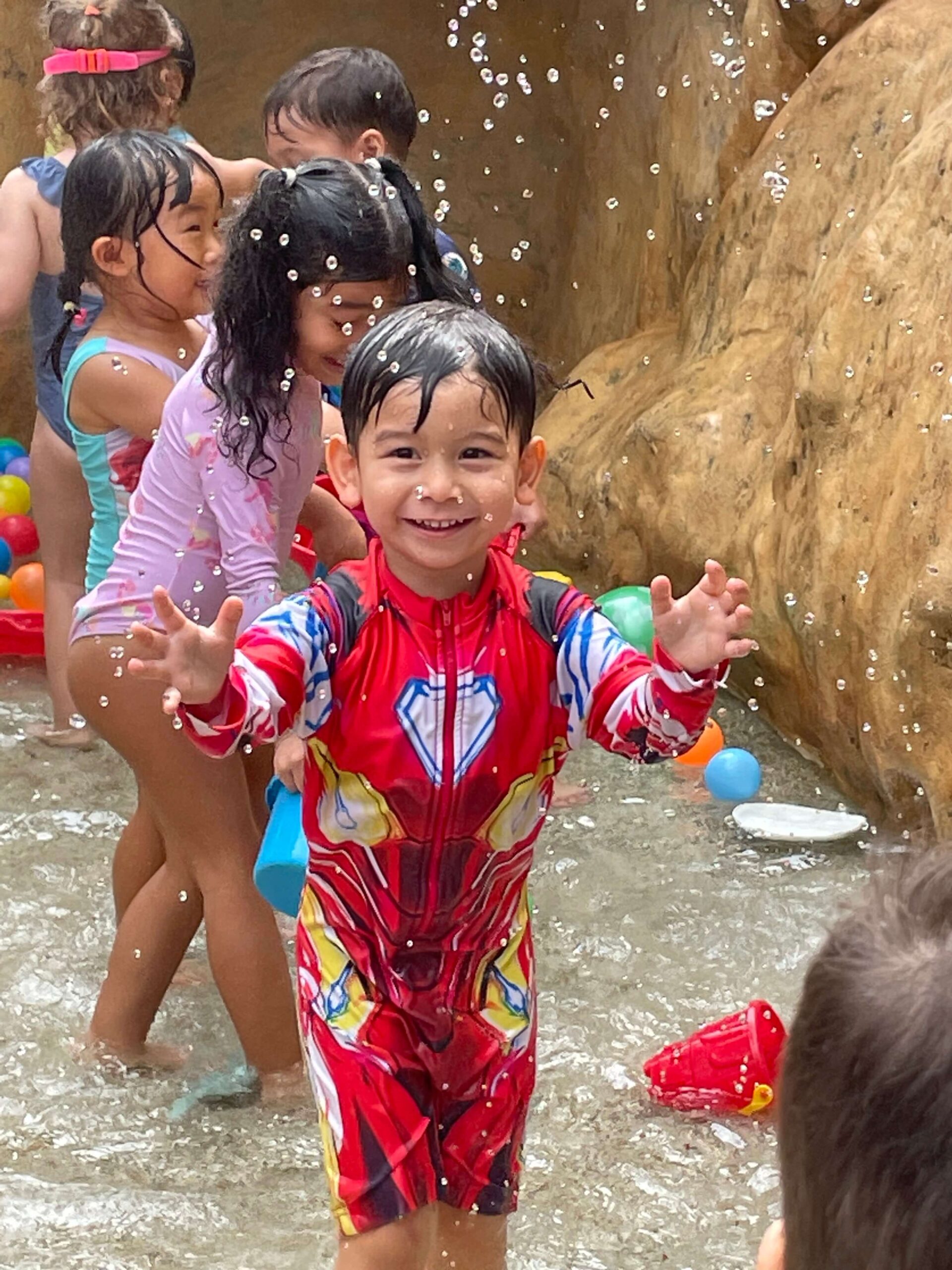 boy playing in water at kindergarten