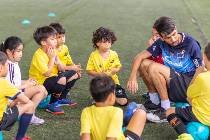 Group kids listen coach for play football