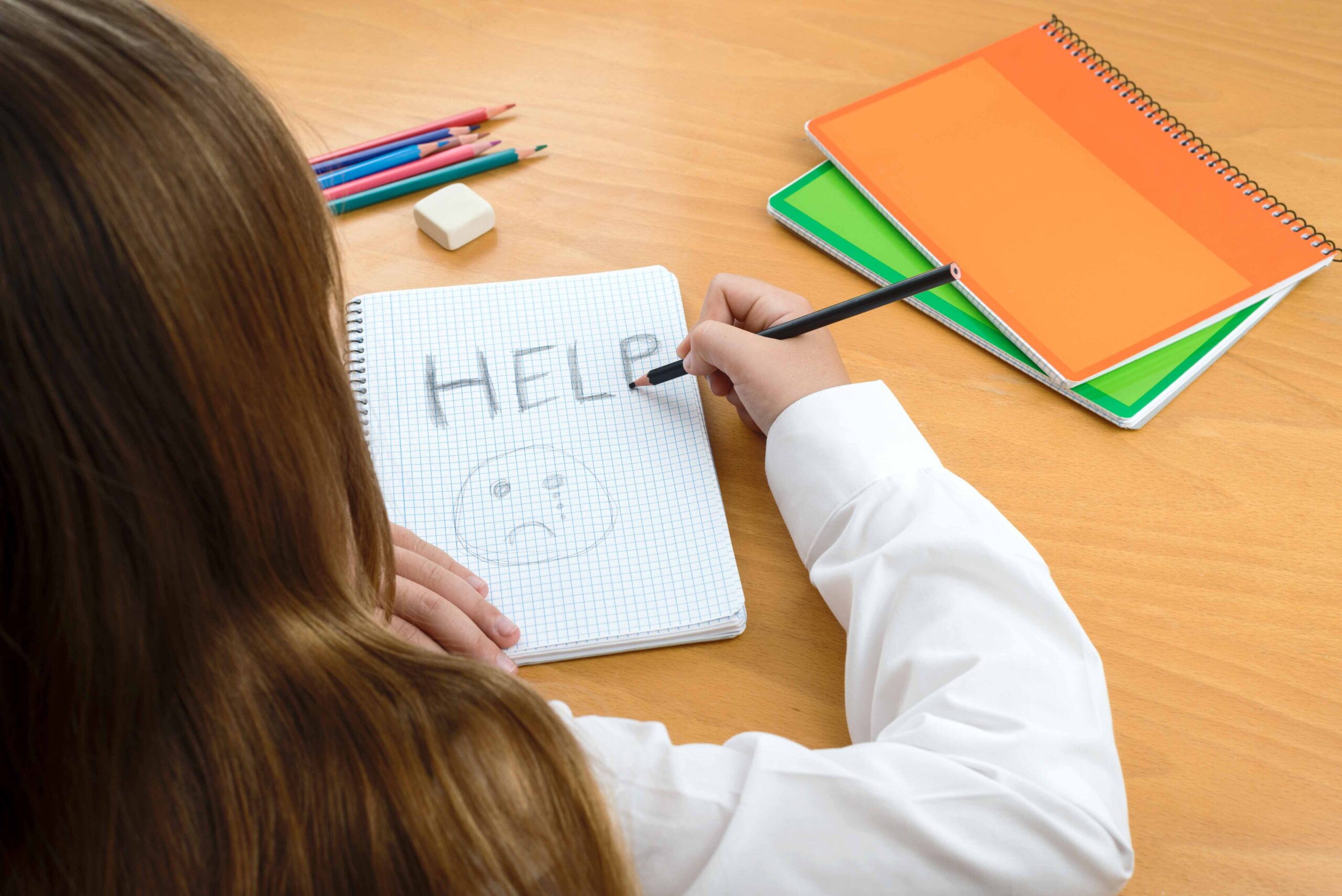Young girl writing a message asking for help