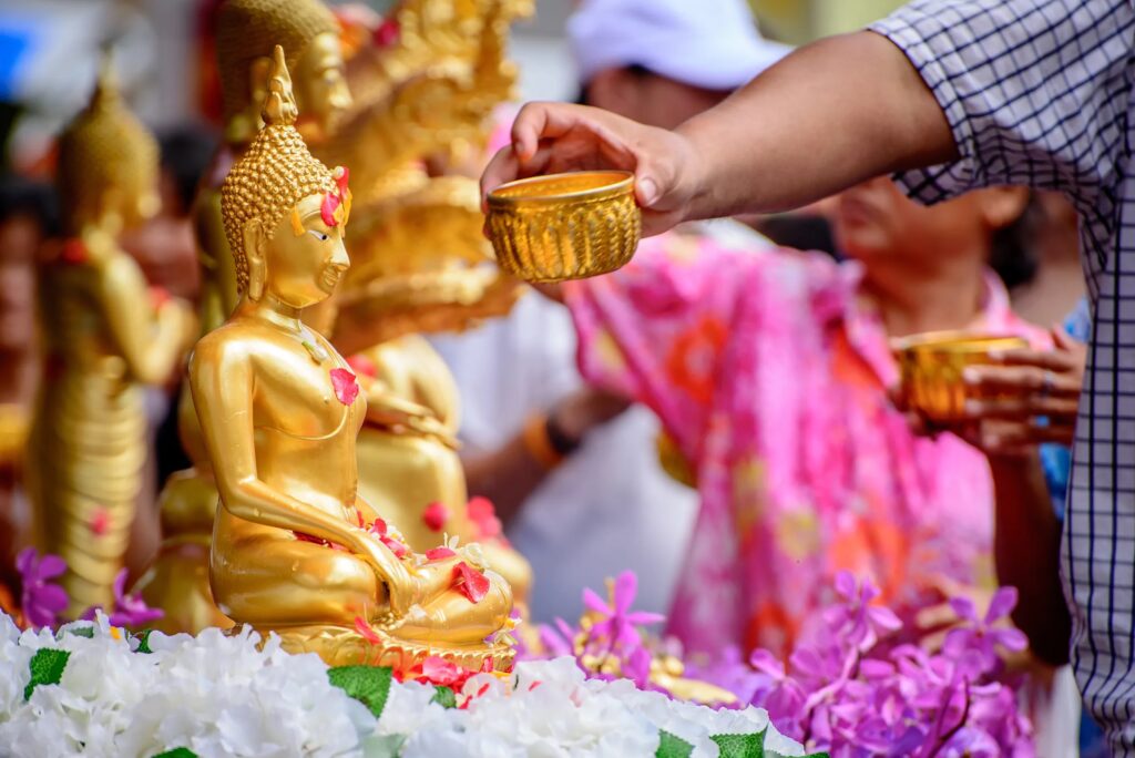 pour water รnto a Buddha statue.