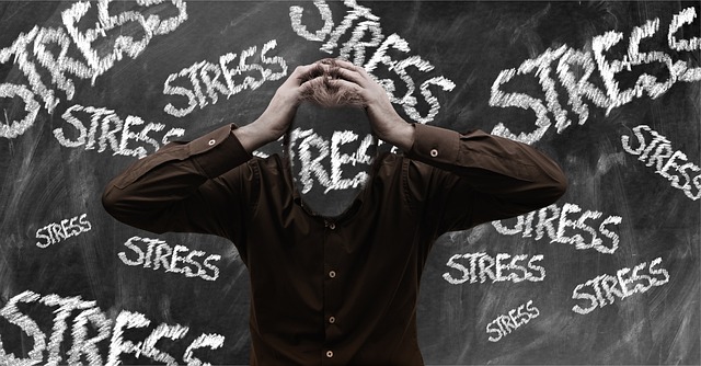 Man showing signs of stress in front of a chalkboard