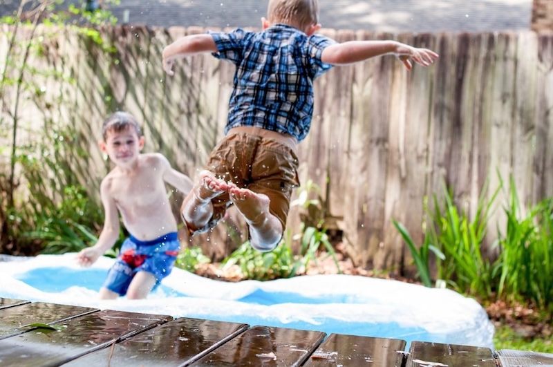 boys jumping in a paddling pool