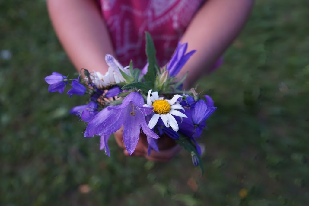 Girl holding a bunch of purple flowers