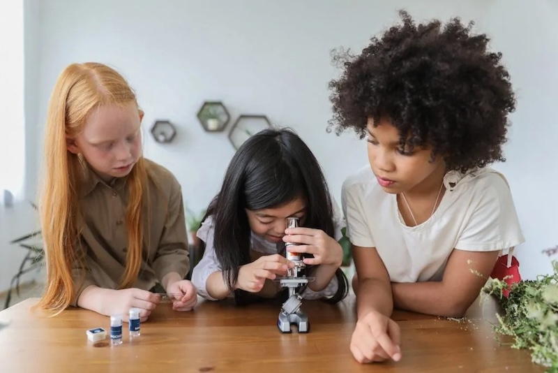 3 kids look with microscope 