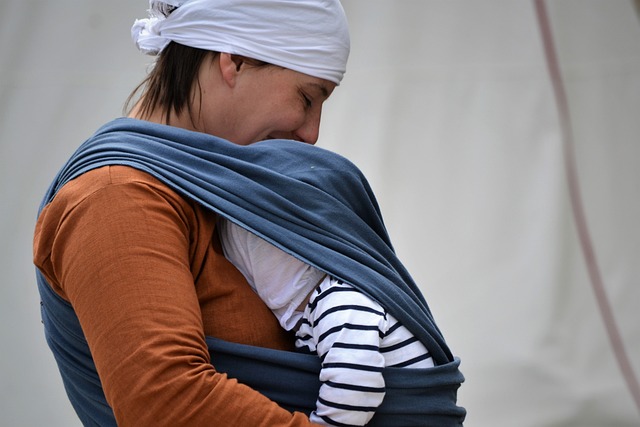 baby in a sling with mother