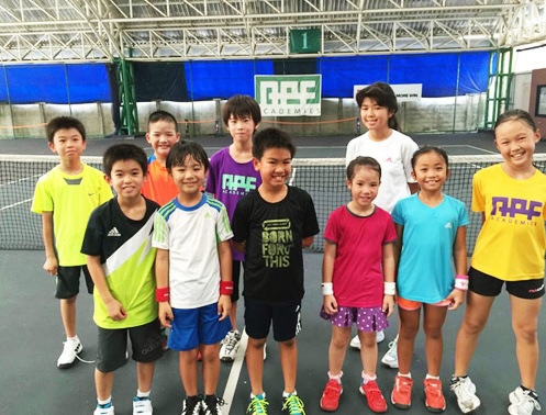 Kids stand in the Tennis court 