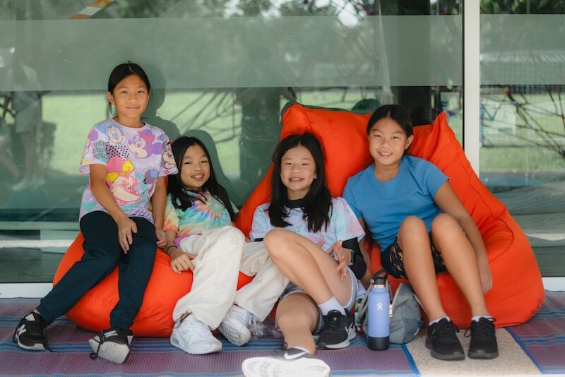 Group of girls siting on beanbags in school playground