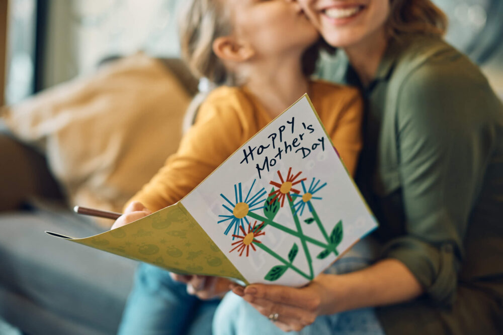 Close-up of woman receiving Mother's day greeting card from her daughter